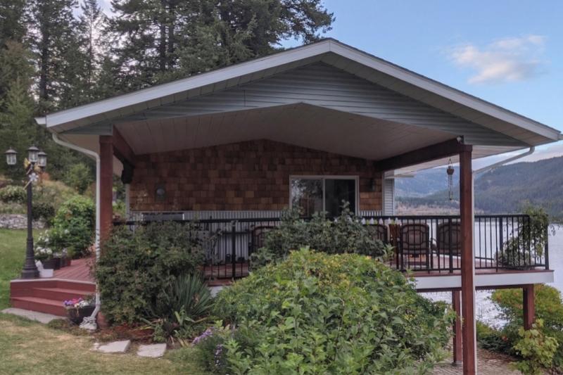 The cozy waterfront deck and cedar siding of Christina Lake House cottage.