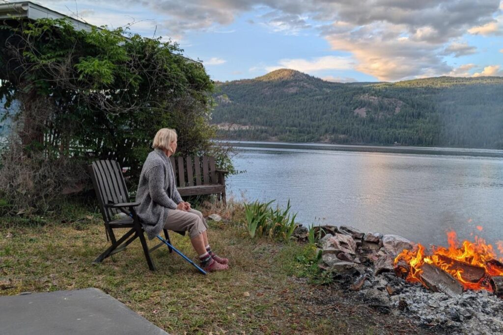 Home Cozy evening campfire at the lakeside stone fire pit.
